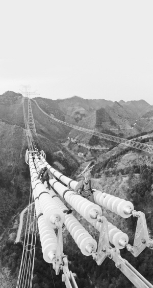 銀色巨龍?jiān)角貛X――昌吉―古泉特高壓陜3標(biāo)段建設(shè)現(xiàn)場(chǎng)走筆　　施工人員在導(dǎo)線上作業(yè)。 　　開(kāi)欄的話：從千里沃野到莽莽群山，從東海之濱到天山腳下，一基基鐵塔拔地而起，一條條銀線伸向遠(yuǎn)方，電能為決勝全面建成小康社會(huì)注入強(qiáng)勁的動(dòng)力
